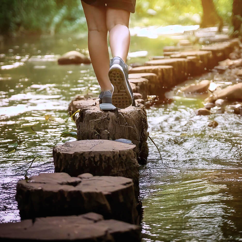 Person walking on stones in river