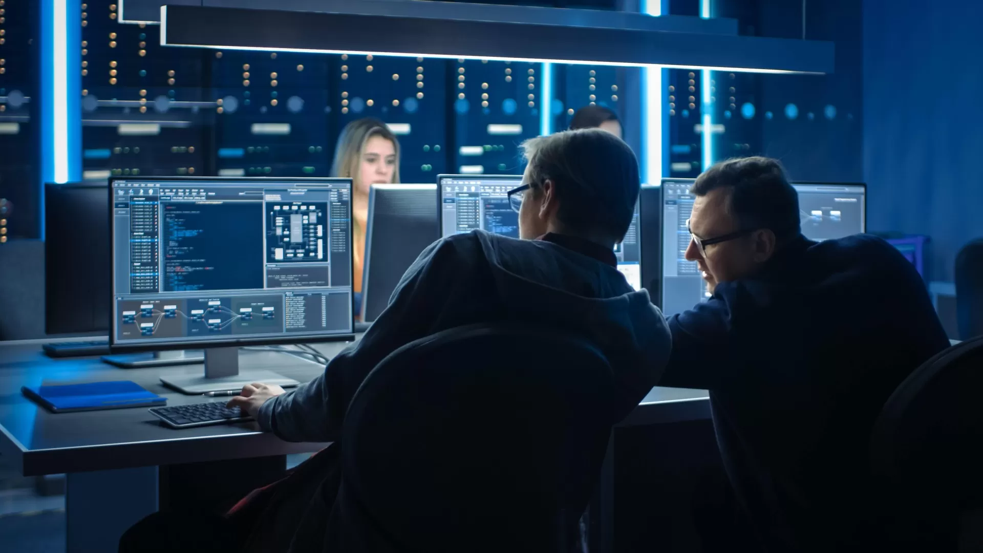 Two men speaking in front of computers